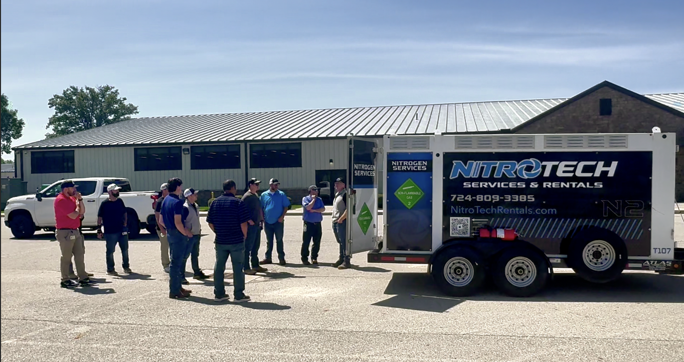Real NitroTech nitrogen trailer hitched to a standard pickup truck at an industrial site — pickup-towable bumper-pull deployment